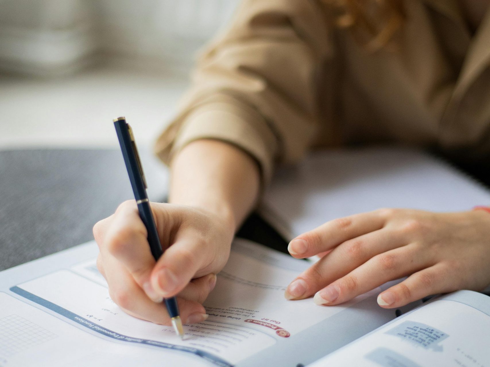 Frau schreibt in ein Übungsheft